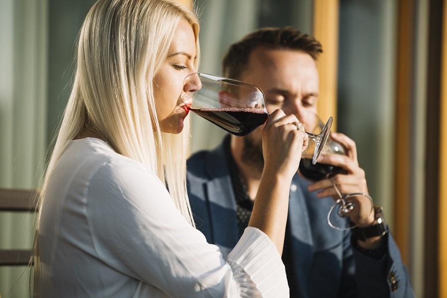 uomo e donna che lavorano nel mondo del vino che degustano un vino