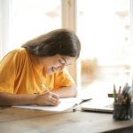 ragazza che studia felice, università telematica
